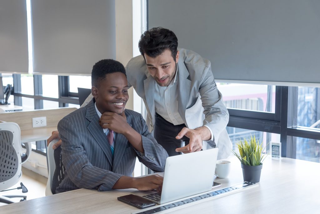 Boss teaching African subordinates with care