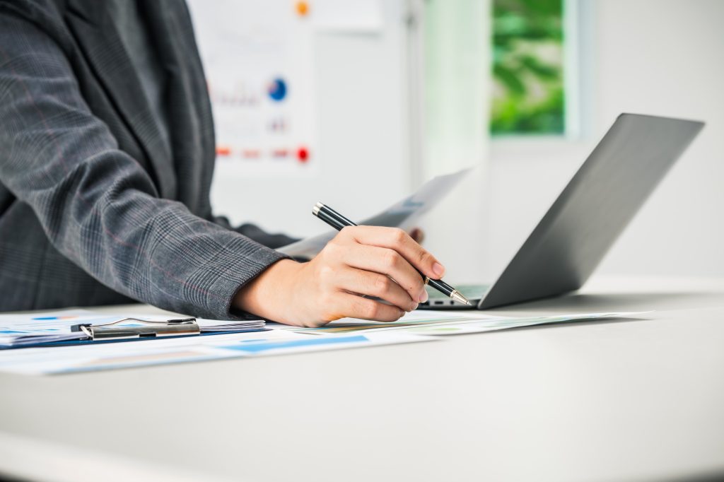 businesswoman works diligently at her desk, reviewing financial documents and analyzing investment
